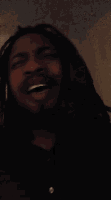 a man with long hair and a beard is making a funny face .