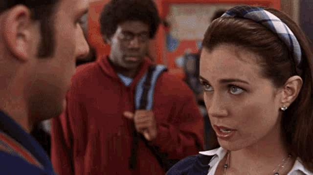 a woman in a plaid headband is talking to a man