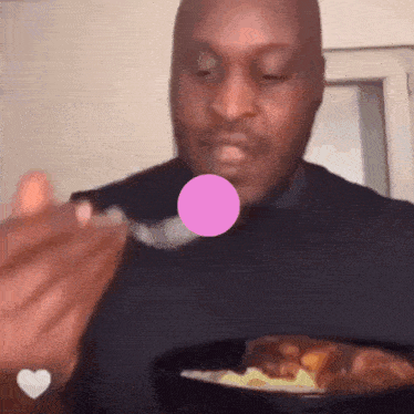 a man is eating a bowl of food with a pink bubble coming out of his mouth .
