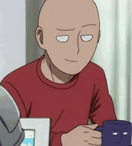 a bald man is sitting at a table holding a cup of coffee and smiling .