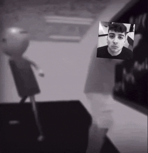 a black and white photo of a man in a black shirt with a picture of another man behind him