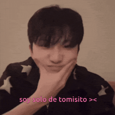 a man is making a funny face with his hand on his face and the words `` soy solo de tomisito '' written in pink .