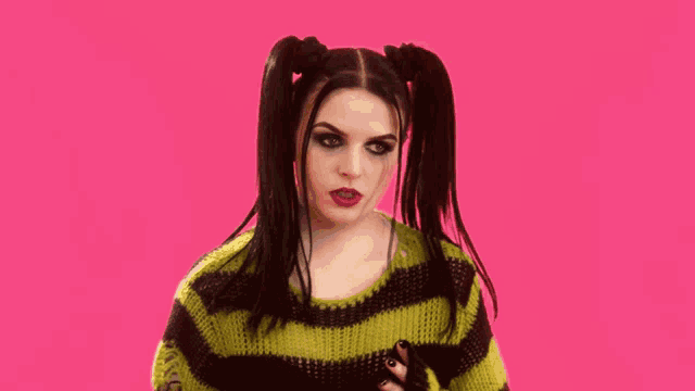 a woman with pigtails is wearing a yellow and black sweater