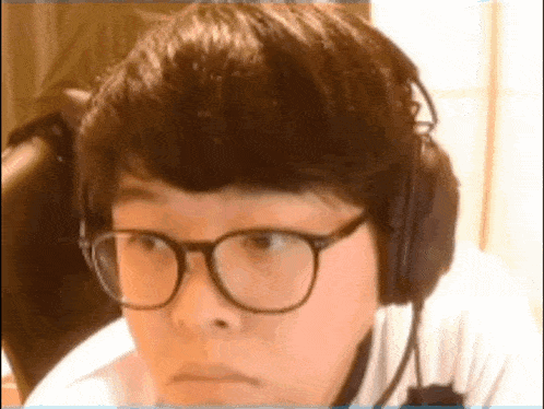 a man wearing glasses and headphones is making a face .