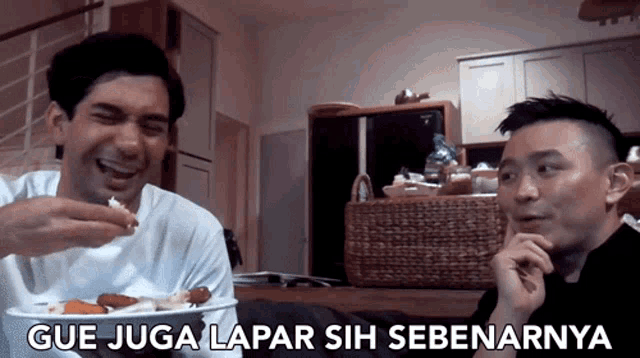 two men are laughing and eating food with the caption gue juga lapar sih sebenanya