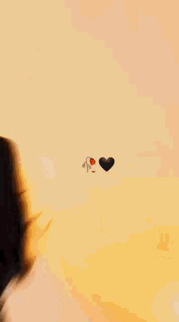 a silhouette of a woman standing next to a man with balloons and a heart in the sky .