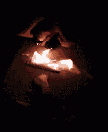 a person is lighting a lighter on a piece of paper