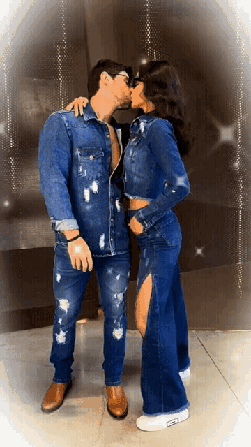 a man and a woman in matching denim outfits kiss