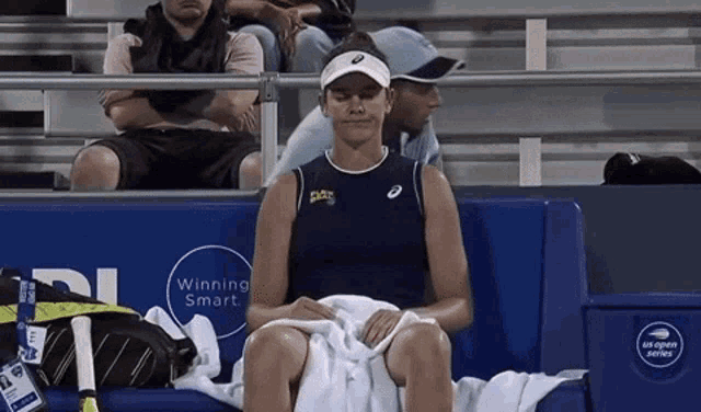 a woman is sitting on a couch with a towel around her waist and a sign that says winning smart on it