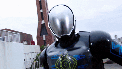 a robot with a helmet on is standing in front of a brick building