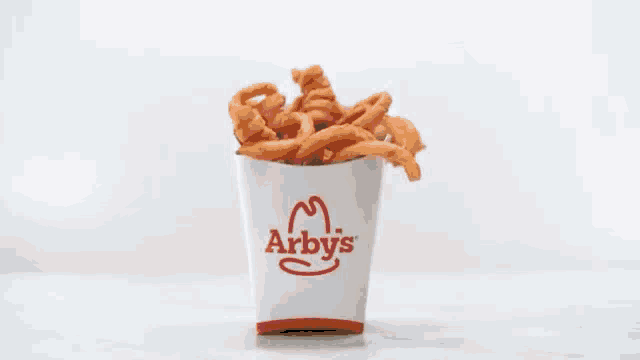 a close up of a chicken nugget being thrown in the air on a white surface .