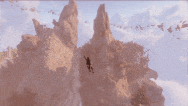 a person is climbing up a rocky cliff with a rope