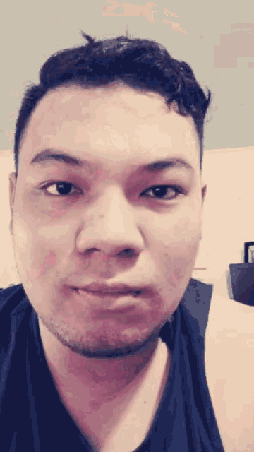 a close up of a man 's face with a black shirt on
