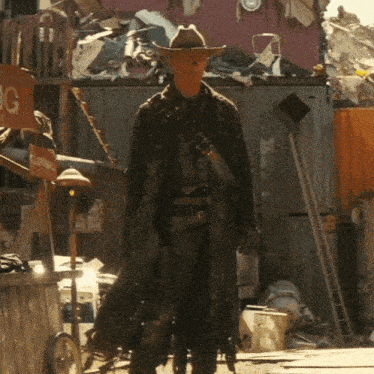 a man in a cowboy hat is standing in front of a clothing store