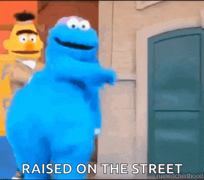 cookie monster from sesame street is standing in front of a building .