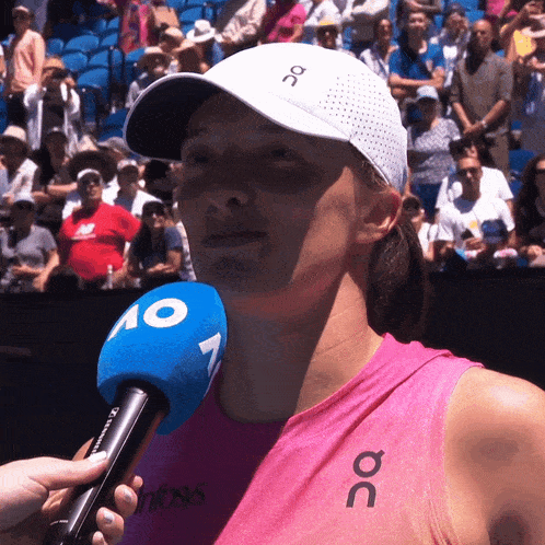 a woman wearing a pink tank top with the word oc on it is being interviewed