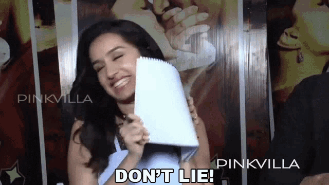 a woman holding a piece of paper that says " do n't lie " on it