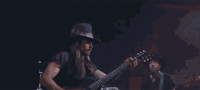 a man in a top hat playing a guitar