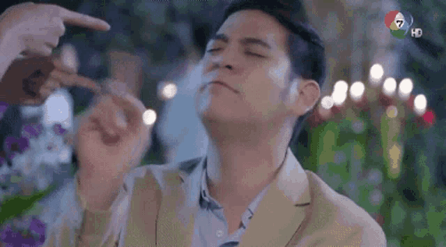 a man in a suit is making a funny face while a woman points at him .
