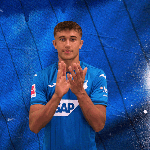 a young man wearing a blue shirt with the word sap on it