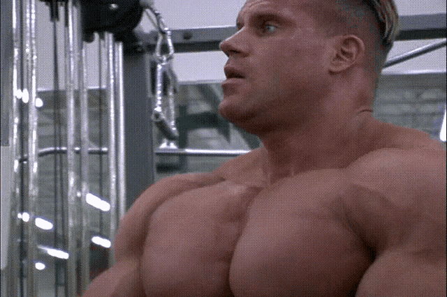 a man with a shaved head is using a gym machine