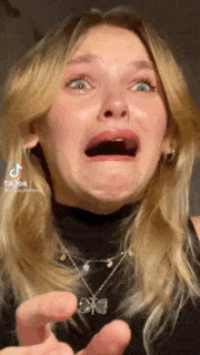 a woman is making a funny face with her mouth open and a necklace .