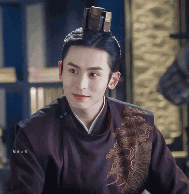 a man with a crown on his head is wearing a purple embroidered jacket