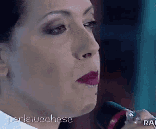 a close up of a woman 's face with purple lipstick on her lips .