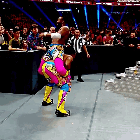 a wrestler is being lifted in the air by another wrestler during a royal rumble