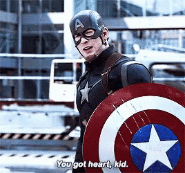 captain america is holding a shield and talking to someone .