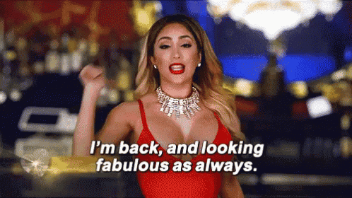 a woman in a red top and necklace is saying i 'm back and looking fabulous as always .