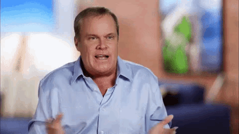 a man in a blue shirt is making a funny face while talking .