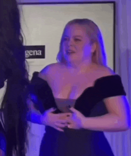 a woman in a black dress is standing next to a woman in a black dress .