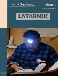 a man with a light on his head is reading a book .