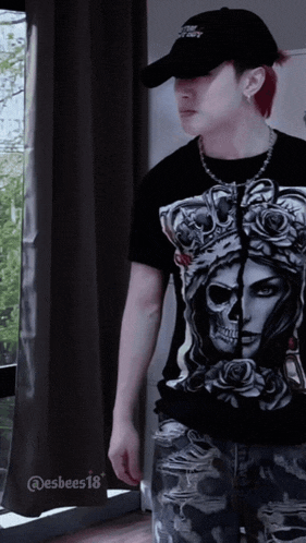 a man wearing a hat and a shirt with a skull on it
