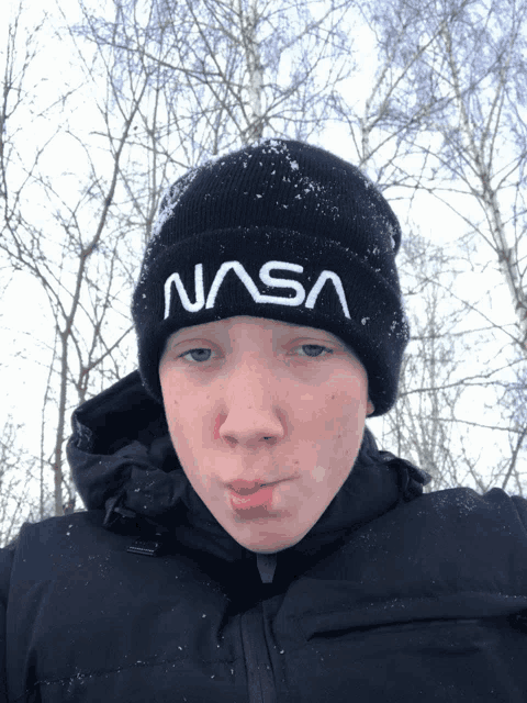 a boy wearing a nasa beanie makes a face