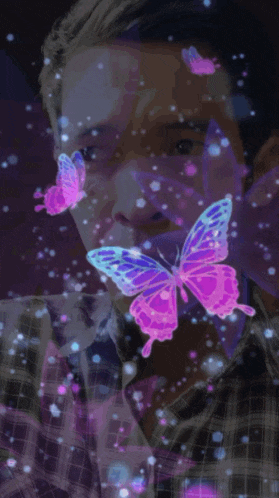 a man in a plaid shirt is surrounded by pink and blue butterflies
