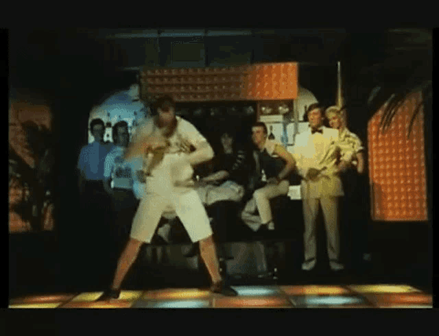 a man is dancing on a dance floor in front of a crowd