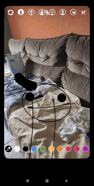 a phone screen shows a drawing of a stick figure on a blanket
