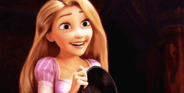 rapunzel from tangled is smiling while holding a black object in her hands .
