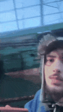 a man with a hood on his head is taking a selfie in a room .