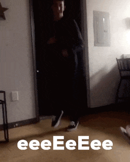 a man is dancing in a room with the words eeeeeee on the floor behind him