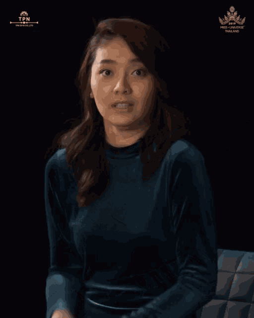 a woman with her hands on her chest in front of a black background that says thailand