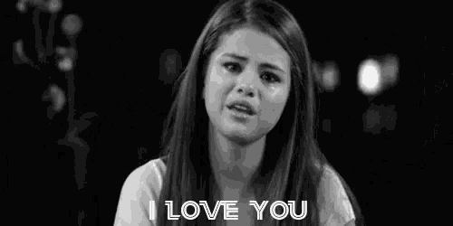 a black and white photo of a woman crying with the words `` i love you '' above her .