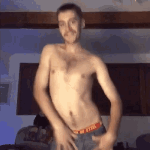 a shirtless man is dancing in a living room