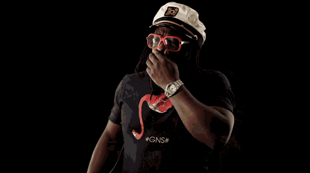 a man wearing sunglasses and a black shirt with the letter t on it