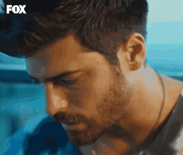 a close up of a man 's face with a fox logo in the background