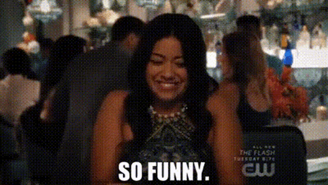 a woman is smiling and saying so funny in a room .