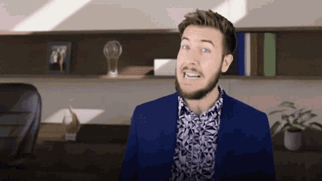 a man with a beard wearing a blue suit and a purple shirt