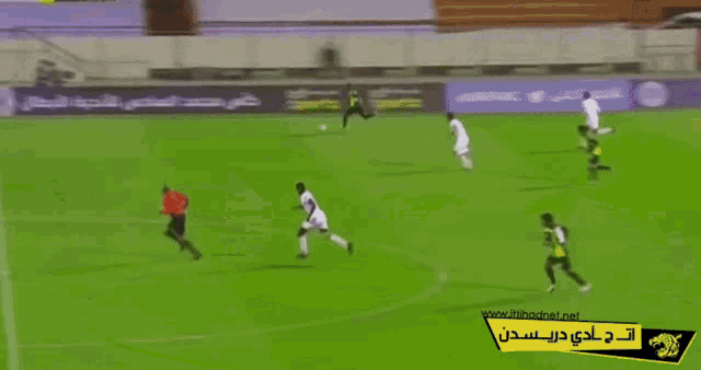 a soccer game is being played on a field with advertisements for sports in the background